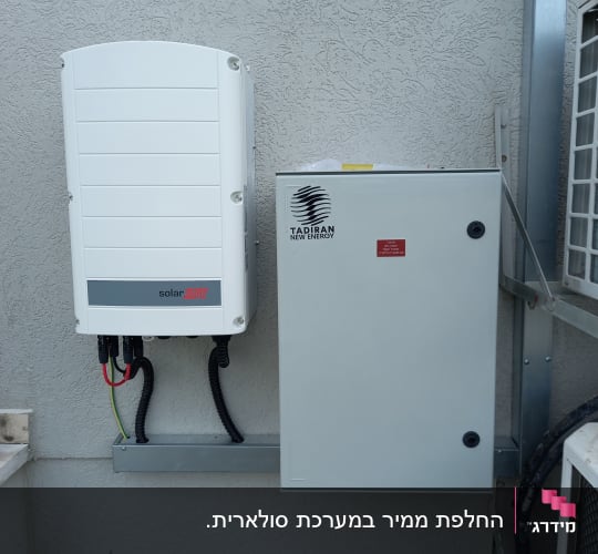 ממיר סולארי וקופסת חשמל מותקנים על קיר חיצוני
